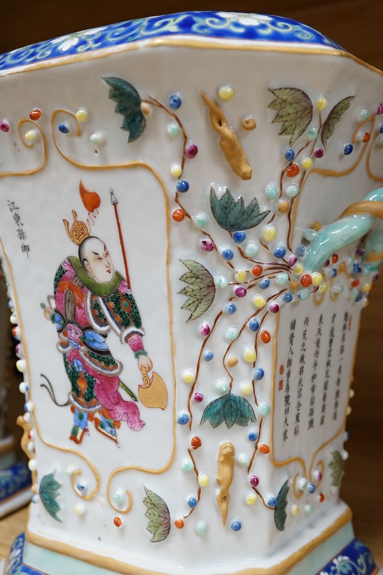 A pair of Chinese famille rose bough pots, painted with figures and calligraphy, 24cm high. Condition - one cover damaged
